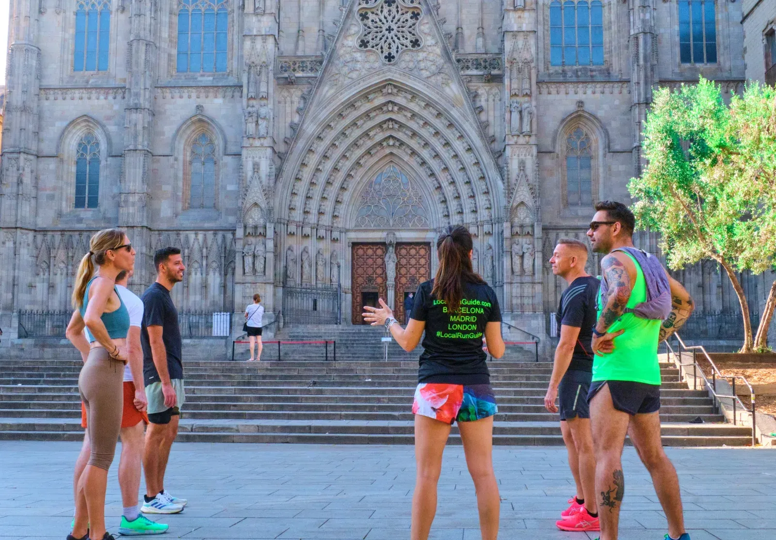 A Local Run Guide sharing stories with a small group outside Barcelona Cathedral